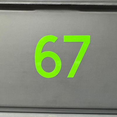 Grüne Zahl 67 auf grauem Hintergrund