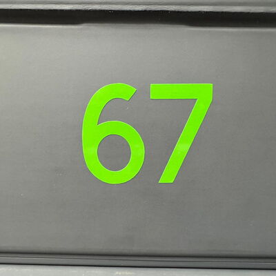 Grüne Zahl 67 auf grauem Hintergrund